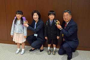 写真：教育長、市長が子どもたちにワッペンを付ける様子