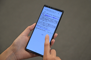 写真：スマートフォンからインターネット市政モニターのアンケートに回答している様子