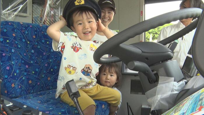 画像：バスの運転席に座って記念撮影する様子
