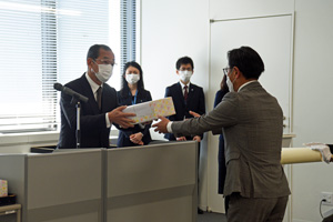 写真：宇田川会長から授与品を受け取る様子