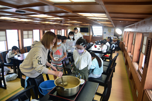 写真：味噌汁をおかわりする小学生たち