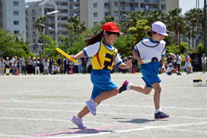 写真：選抜リレーを走る低学年の児童たち
