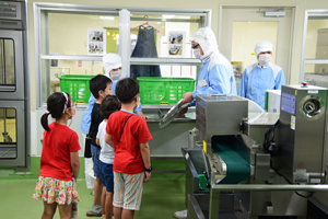 写真：下処理場の説明を聞く児童
