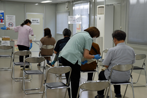 写真：ワクチン接種後、経過を尋ねられる様子