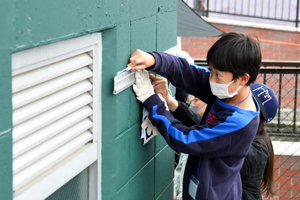 写真：ポンプ場の壁に線を引く子ども