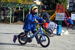 写真：ストライダーをこぐ園児