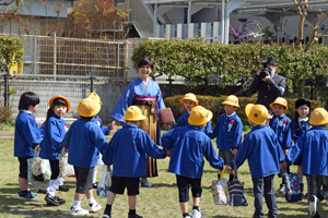 写真：園庭で先生を囲む園児たち