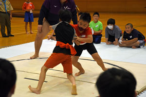 写真：真剣な顔で組み合う小学生たち