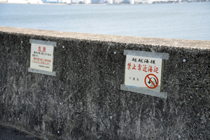 写真：護岸に張られた注意書き