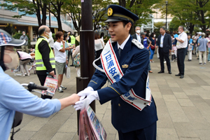 写真：泉澤祐希さんが街頭キャンペーンで啓発物資を配布している様子