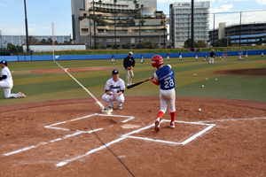 写真：選手が投げるボールでトスバッティングをしている小学生