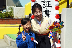 写真：門の前で先生と記念撮影