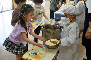 写真：よそってもらった給食を受け取る様子