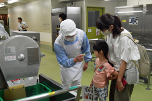 写真：野菜を切る機械を見学する児童