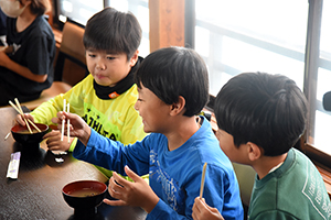 写真：みそ汁を食べる児童たち