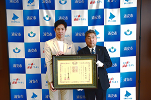 写真：紺綬褒章をもって記念撮影をする昭栄美術社長と内田社長