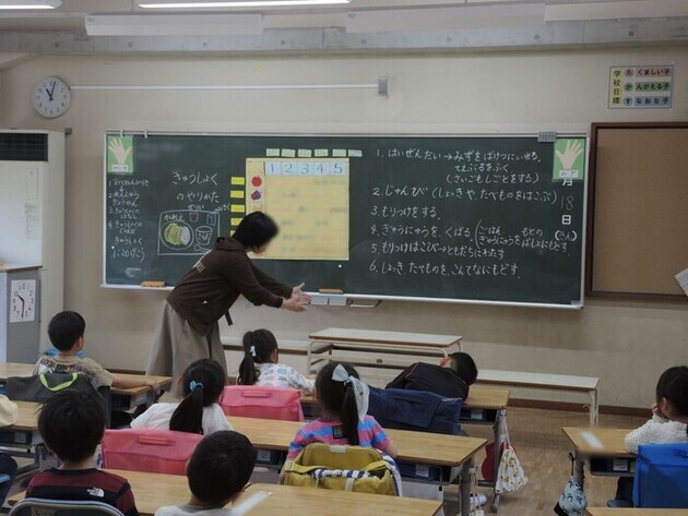 給食の準備の方法を説明する先生