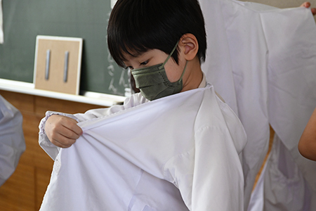 写真：かっぽう着を着る給食当番