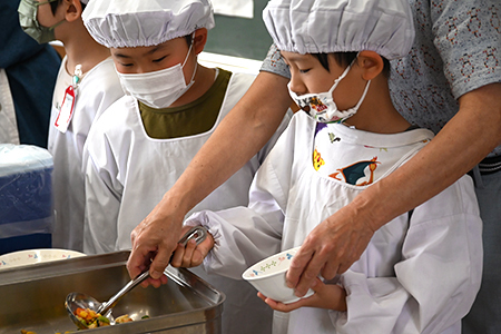 写真：給食をよそう様子