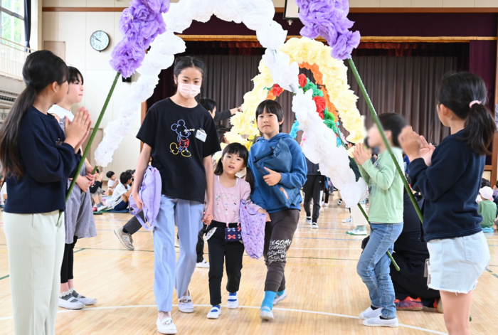 花のアーチをくぐる1年生と6年生