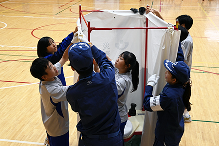 写真：仮設トイレの幕を張る様子