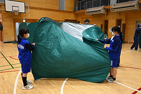 写真：ワンタッチパーテーションを拡げる様子