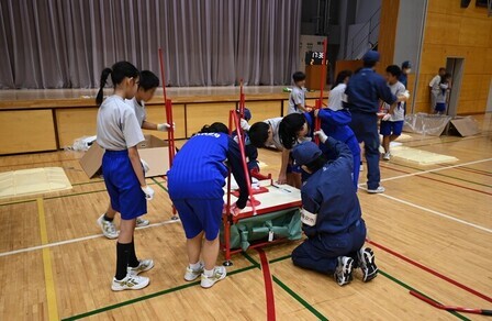 避難所運営訓練にて仮設トイレを組み立てる生徒たち