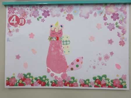 制作したカードのイメージ写真。ピンク色の足形にユニコーンの角や耳、尻尾の飾りを付け、まわりには花の飾りと「4月」の文字が入っています。