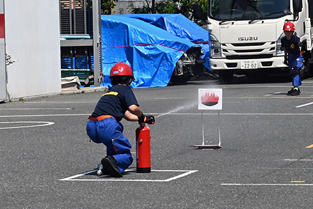 写真：消火器を使って水で的を倒す様子