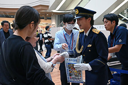 写真：啓発グッズを配る青山さん