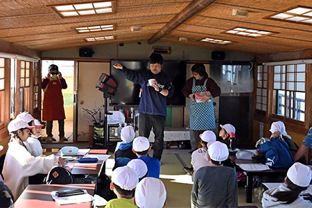 写真:先生が稚貝放流の説明をする様子