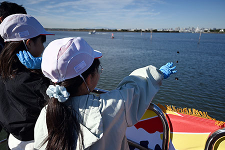 写真:稚貝を投げる様子