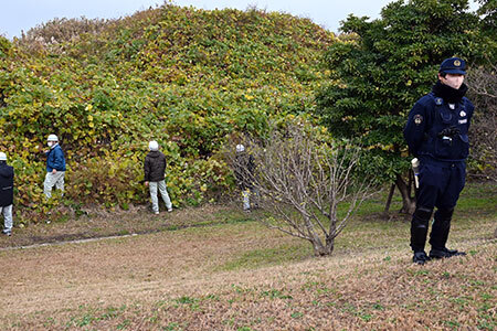 写真:捜索をする職員と付近を警備する警察の方