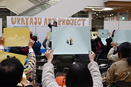 写真：穴の開いた紙を持つ会場の方たち