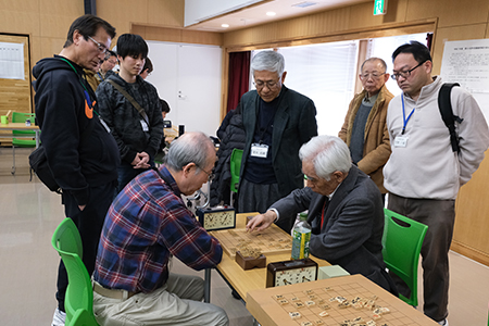 写真3：対局を見学する参加者たち