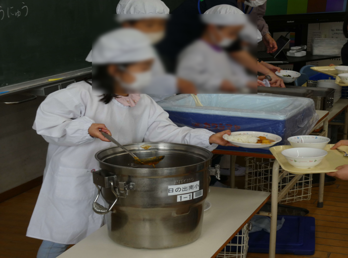 給食を配膳する児童