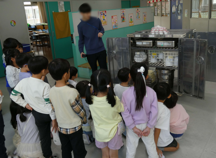 給食の準備の方法を説明する先生