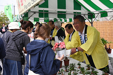 写真：植木まつりで内田市長が苗を渡す様子