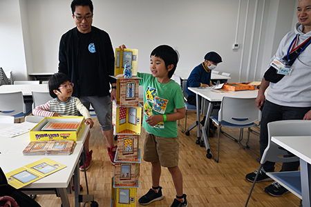 写真：本を積むゲームを楽しむ親子