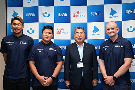 写真：ラウンツリーヘッドコーチ、藤村選手らと市長の記念撮影