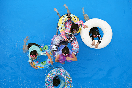 写真：浮き輪に乗って遊ぶ子供たち