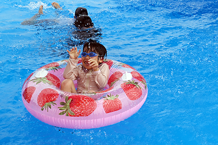 写真：橋の上から降ってくるシャワーに喜ぶ子供