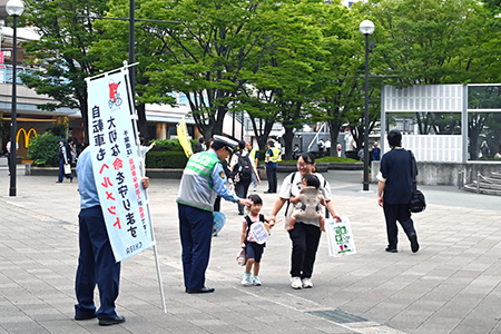 写真：防犯啓発物品を受け取るお母さんと子供