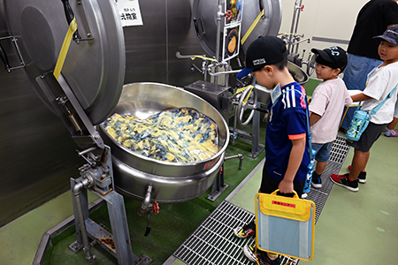 写真：調理機器をのぞき込む児童