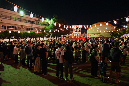 盆踊り大会の会場の様子。やぐらの周りにたくさんの人が集まっています。